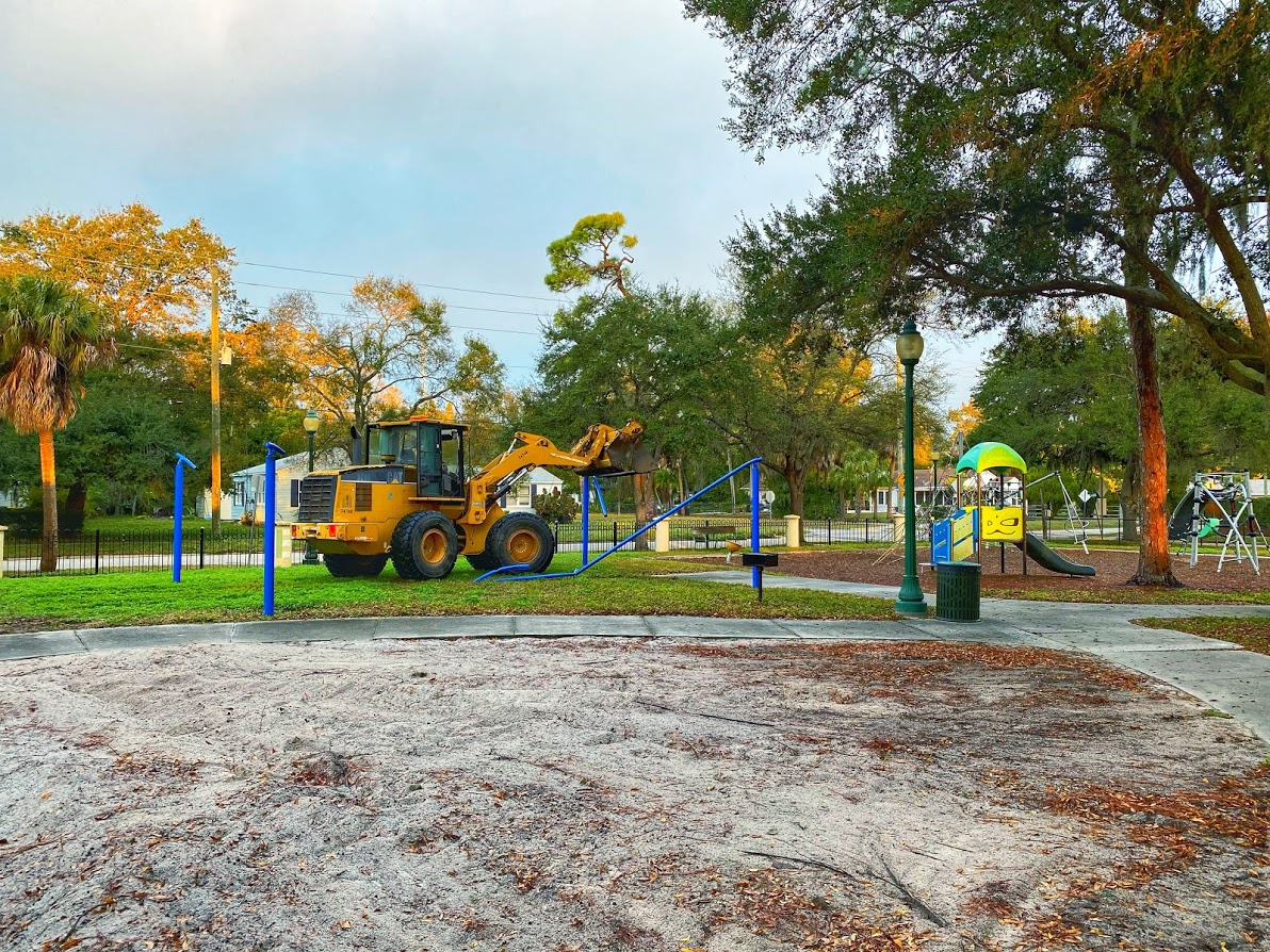 Construction truck is taking down the metal poles of the shade structure. The location is mary dean park on a cold winter morning.